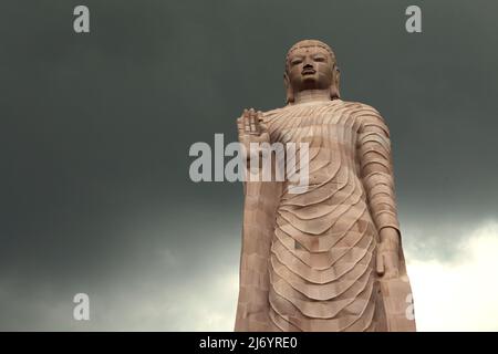 Una statua in pietra arenaria alta 80 piedi del Buddha in piedi a Sarnath alla periferia di Varanasi, Uttar Pradesh, India. Costruita dal 1997 al 2011, la statua fu il risultato di uno sforzo congiunto tra Thailandia e India. Foto Stock