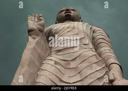 Una statua in pietra arenaria alta 80 piedi del Buddha in piedi a Sarnath alla periferia di Varanasi, Uttar Pradesh, India. Costruita dal 1997 al 2011, la statua fu il risultato di uno sforzo congiunto tra Thailandia e India. Foto Stock