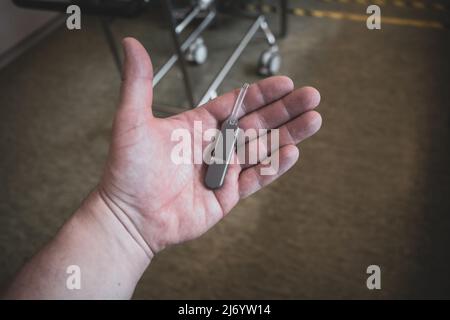 in una mano vi è un registratore di eventi impiantabile per registrare problemi cardiaci Foto Stock