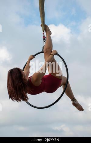 Aerialista femminile che si esibisce su un cerchio Foto Stock