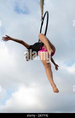 Aerialista femminile che si esibisce su un cerchio Foto Stock