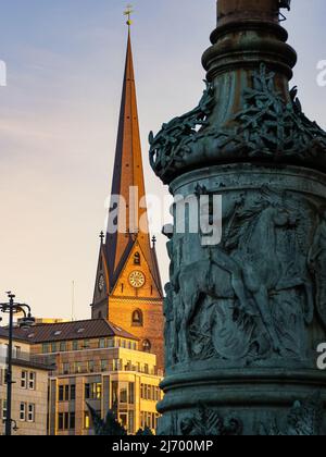 fotografia verticale con vista dalla piazza della città di amburgo al tetto della torre dell'orologio della chiesa di san pietro durante il tramonto. Foto Stock