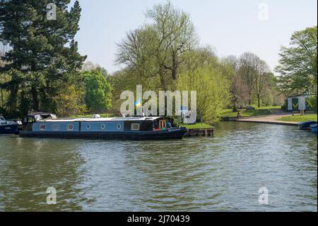 Barca stretta Guinevere, battenti bandiera Ucraina, ormeggiata bankside sul Tamigi in una giornata di primavera soleggiata. Windsor, Berkshire, Inghilterra, Regno Unito. Foto Stock