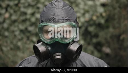 Uomo in tuta di protezione chimica, respiratore e occhiali da primo piano Foto Stock