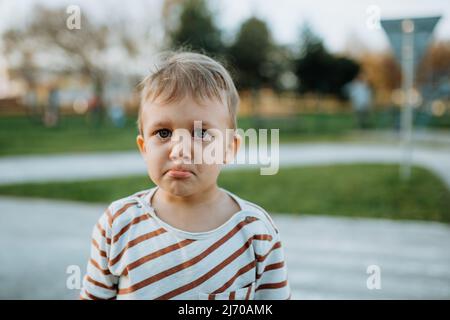 Ragazzino triste che piange fuori nel parco Foto Stock