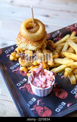 Mac Attack Burger sormontato con mac e formaggio con patatine fritte a Liquor & Loaded, King's Lynn, Norfolk, Regno Unito Foto Stock