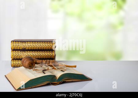 Primo piano di un libro antico con una pipa di tabacco su di loro e un paio di bicchieri e una pila di tre libri di fronte a sfondo luminoso. La giornata degli insegnanti Foto Stock