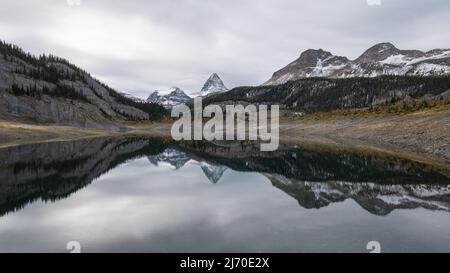Prominente montagna che si riflette nel lago alpino durante la giornata colma, Pano, Mt Assiniboine PP, Canada Foto Stock