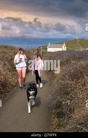 Camminatori di cani e un cane che si gode una passeggiata sul sentiero costiera intorno a Newquay in Cornovaglia nel Regno Unito. Foto Stock