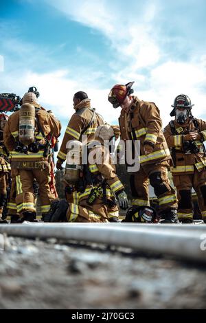 316th Ingegnere civile Squadron pompieri indossare dispositivi di protezione personale durante un addestramento interagenzia antincendio presso la Joint base Andrews, Md., 2 maggio 2022. I membri del CES 316th e dell'Ala delle operazioni speciali 193rd si sono riuniti per un addestramento simulato di lotta al fuoco dal vivo al fine di acquisire un'esperienza realistica e rafforzare i legami tra le agenzie. (STATI UNITI Air Force foto di Senior Airman Bridgitte Taylor) Foto Stock