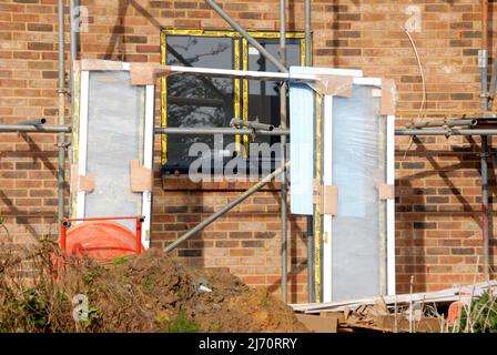 Cornice per porte patio, appoggiata contro ponteggi, in attesa di essere installato in una casa in costruzione Foto Stock