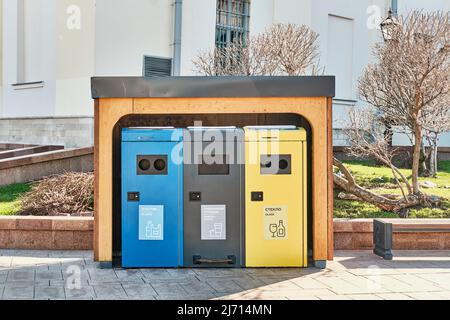 Contenitori multicolore come contenitori per rifiuti per la raccolta di rifiuti nelle strade urbane. Foto Stock