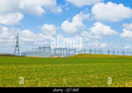 Torri elettriche ad alta tensione, linee elettriche di trasmissione, cavi su trasformatori e sottostazione di distribuzione Foto Stock