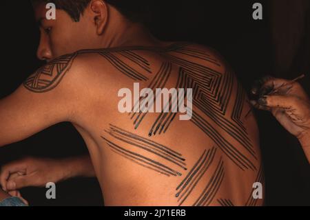 Giovane uomo tribale con il suo corpo dipinto con arte tribale Baixo Amazonas, Rio Xingu, Amazzonia brasiliana, 2007. Foto Stock