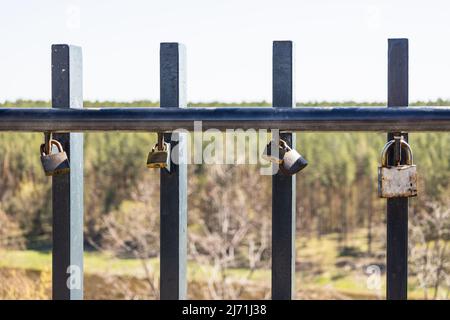 Primo piano vista di lucchetti d'amore appesi su una recinzione ponte Foto Stock