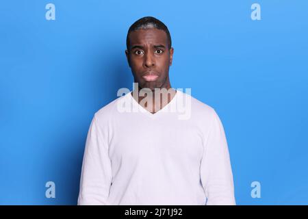 Triste uomo nero doloroso guarda la macchina fotografica con espressione miserabile Foto Stock