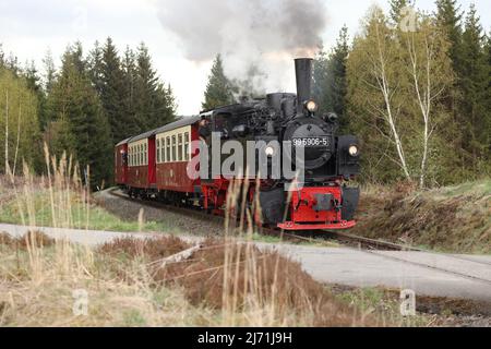 05 maggio 2022, Sassonia-Anhalt, Benneckenstein: Un treno speciale della Harzer Schmalspurbahn GmbH è trainato dalla locomotiva Mallet del 99 5906. È l'ultimo mazzetto operativo di questo tipo a funzionare sull'HSB. A 104 anni di età, è ora in pensione. A partire da oggi, ci sarà una serie di viaggi speciali come tour di addio per la locomotiva a vapore. A partire da metà maggio, la locomotiva non sarà più utilizzata. Foto: Matthias Bein/dpa/ZB Foto Stock