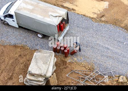 Sostituzione di bombole rosse contenenti propano per il taglio di metalli, fuoco selettivo Foto Stock