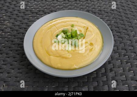 Purea di piselli spaccati gialli con olio d'oliva e cipolline verdi. Fava cibo greco. Foto Stock