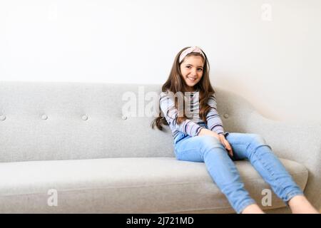 Girl Changing Channel With Remote Control In Front Of Television At Home Stock Photo