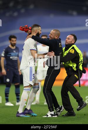 Madrid, Spagna, 4th maggio 2022. Un invasore di campo che sventola una bandiera albanese corre per abbracciare Karim Benzema del Real Madrid mentre viene perseguito dagli steward durante la partita della UEFA Champions League al Bernabeu di Madrid. Il credito d'immagine dovrebbe essere: Jonathan Moscrop / Sportimage Foto Stock