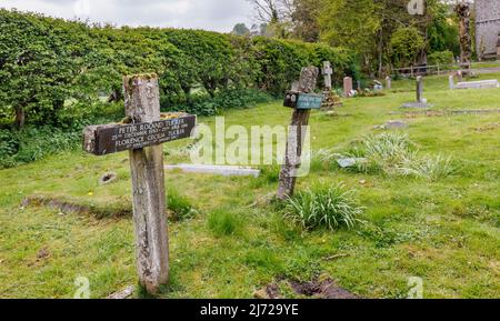 Croci di legno sulle tombe nel cimitero di St Michael e tutti gli Angeli chiesa parrocchiale a Shelbourne, un piccolo villaggio nella rurale Wiltshire, Inghilterra Foto Stock