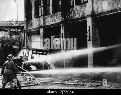 Affrontare un incendio causato da bombe incendiarie giapponesi durante un raid a Singapore. Gennaio 28, 1942. Foto Stock