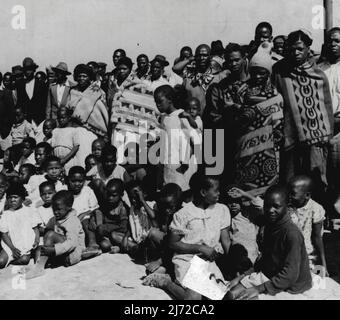 "Block out for Natives" - civiltà a Johannesburg, Sudafrica. Tra gli spettatori della danza tribale in goldminers compound sono i 'ragazzi' miniera - minatori giovani. Appena reclutato dalle giungle -- si aggrappano al loro garb nativo delle coperte colorate luminosamente. Altri hanno adottato gli stili di civiltà. Febbraio 16, 1953. (Foto di Pix Publishing Inc.). Foto Stock