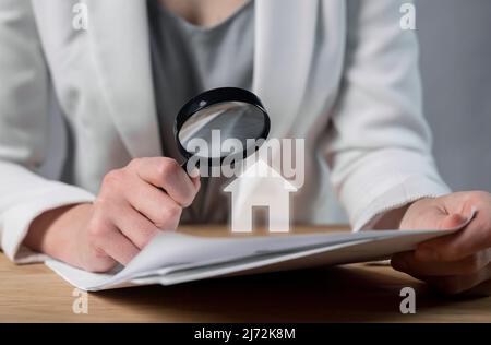 Cliente che studia acquisto di bene immobile, contratto d'affitto, prestito o contratto di ipoteca. Donna mani con lente d'ingrandimento closeup. Legalità e trasparenza dei contratti. Entrare in una nuova casa. Foto di alta qualità Foto Stock