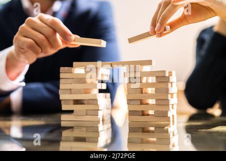 Close-up di umana la mano posizionando il blocco di legno su scrivania Foto Stock