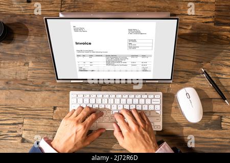Contabile che utilizza la fattura elettronica sul computer portatile per ufficio Foto Stock