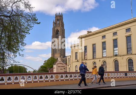 Persone che attraversano un ponte con una cattedrale sullo sfondo a/Boston, Regno Unito Foto Stock