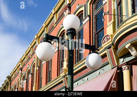 Ellensburg, WA, USA - 04 maggio 2022; lampada da strada a tre sfere contro l'iconico edificio Davidson di Ellensburg Foto Stock