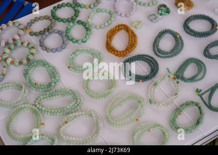 Primo piano di vari bracciali e bracciali colorati in gemma in vendita sul mercato Foto Stock