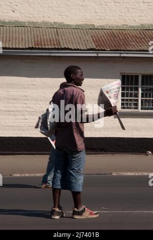 Ragazzi che vendono giornali, fuori da un vecchio edificio amministrativo, Blantire, Malawi, Africa. Blantyre (che prende il nome dal luogo di nascita di David Livingstone a SCO Foto Stock