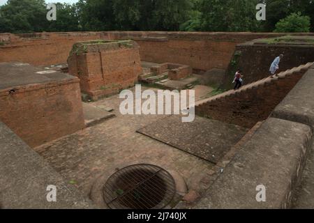 Persone che saliscono le scale al resto di un antico monastero costruito da un re Srivijaya nel 9th secolo, situato nelle rovine dell'antica università buddista di Nalanda a Nalanda, Bihar, India. Un'iscrizione copperplate trovata in questo luogo è un record ufficiale del più antico rapporto bilaterale tra due regni nell'attuale India e Indonesia (pala e Srivijaya). Foto Stock