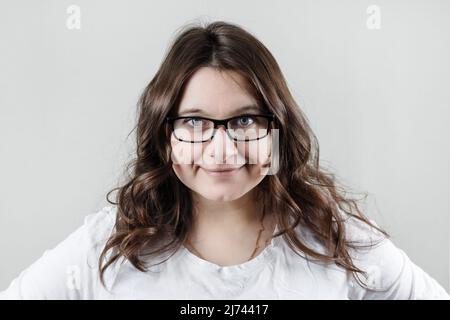 Donna che indossa occhiali. Donna d'affari che sorride e guarda la macchina fotografica. Foto Stock