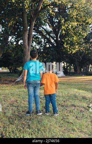 due bambini che tengono le mani nella foresta, fratelli insieme, Foto Stock