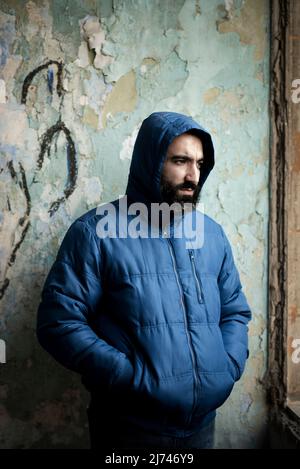 Uomo medio orientale con bearded che indossa la giacca con cappuccio Foto Stock