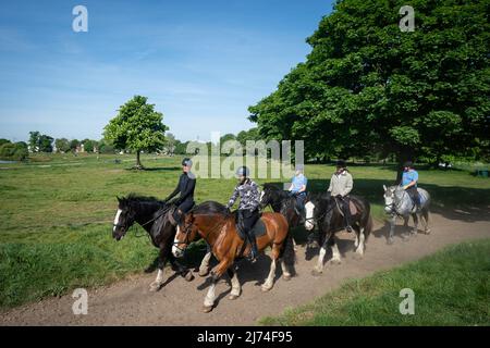 Persone che cavalcano cavalli lungo Wimbledon Common a Londra. Data foto: Venerdì 6 maggio 2022. Foto Stock