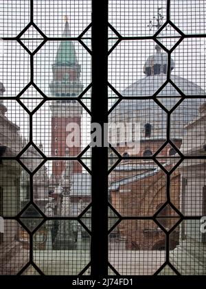 Italien Venedig Markusdom -107 Blick aus einem vergitterten Fenster des Dogenpalastes auf eine Kuppel des Markusdomes und den Campanile Foto Stock