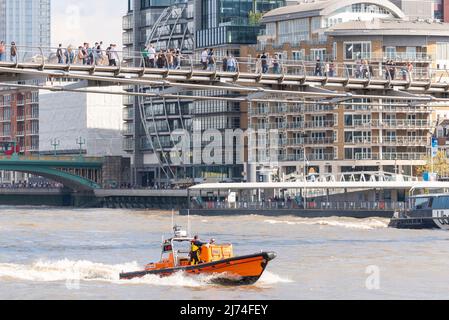 RNLI Tower Lifeboat Station e class imbarcazione di salvataggio costiera e-07 chiamata Hurley Burly, un motoscafo veloce a getto d'acqua. Passando sotto il Millennium Bridge Foto Stock