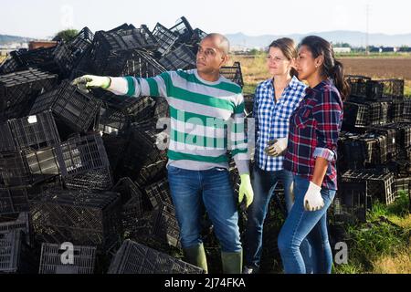Giardinieri che parlano su fattoria vicino scatole vuote Foto Stock