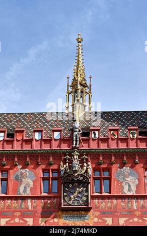 Basilea, Svizzera - Aprile 2022: Vista frontale esterna dell'orologio e della guglia del Municipio di Basilea o Rathaus, come è noto localmente Foto Stock