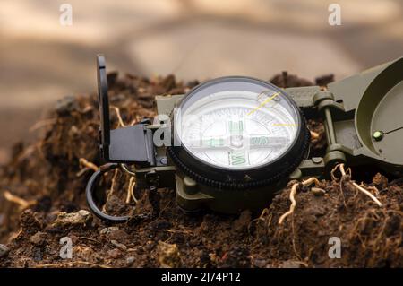 Una bussola magnetica verde dell'esercito a terra Foto Stock