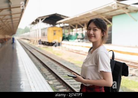 Ritratto giovane donna asiatica zaino in spalla viaggio alla stazione ferroviaria. Foto Stock