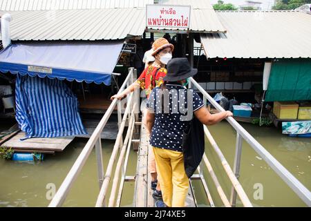 I viaggiatori stranieri della gente thailandese viaggiano a piedi per visitare lo shopping dal negozio di alimentari in barca a legno presso il tempio locale Talad Nam Lumphaya o Wat Lam Phaya Floating Foto Stock