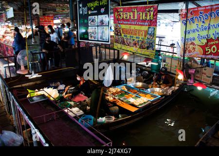 I viaggiatori stranieri della gente thailandese viaggiano a piedi per visitare lo shopping dal negozio di alimentari in barca a legno presso il tempio locale Talad Nam Lumphaya o Wat Lam Phaya Floating Foto Stock