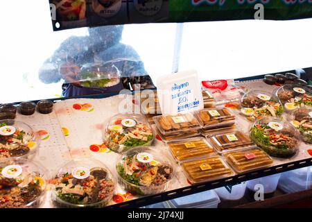 I viaggiatori stranieri della gente thailandese viaggiano a piedi per visitare lo shopping dal negozio di alimentari in barca a legno presso il tempio locale Talad Nam Lumphaya o Wat Lam Phaya Floating Foto Stock