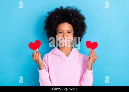 Foto di giovane bella ragazza tenere piccolo carta cuore cupido romantico sogno dono isolato su sfondo blu colore Foto Stock